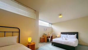 A hotel room with a bed, a desk, a chair, and a small table with a lamp. - City Center Stay, With Parking (Hobart)
