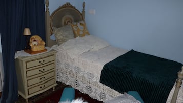 Cozy retreat with a traditional bed, wooden headboard, and a nightstand with a lamp.