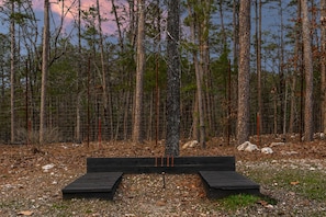 A forested area with a wooden platform and a wire fence. - As Seen on TV! Safari Views + Hot Tub + Firepit (Broken Bow)