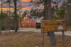 A rustic cabin with a wooden sign reading 'Perfection Peak.' - NEW! Prime Cabin, Hot Tub-Firepit-Safari, Sleeps 8 (Broken Bow)