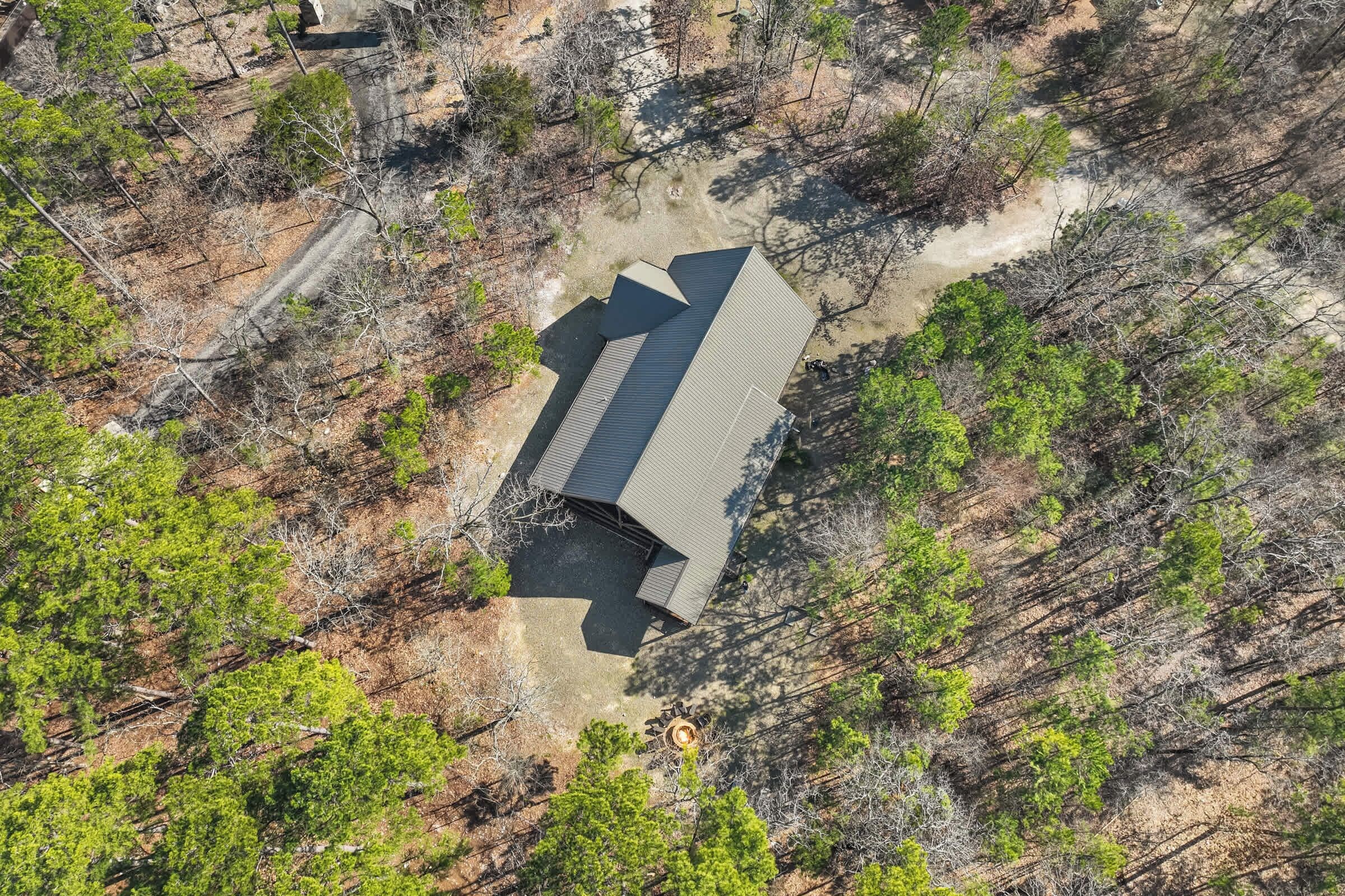 A single-story building with a sloped roof, surrounded by dense forest.