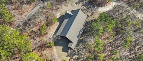A single-story building with a sloped roof, surrounded by dense forest.