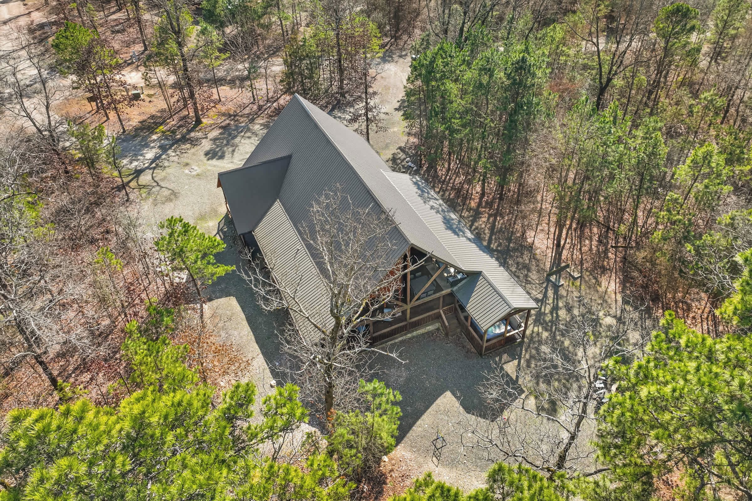 A cabin with a sloped roof surrounded by dense forest.