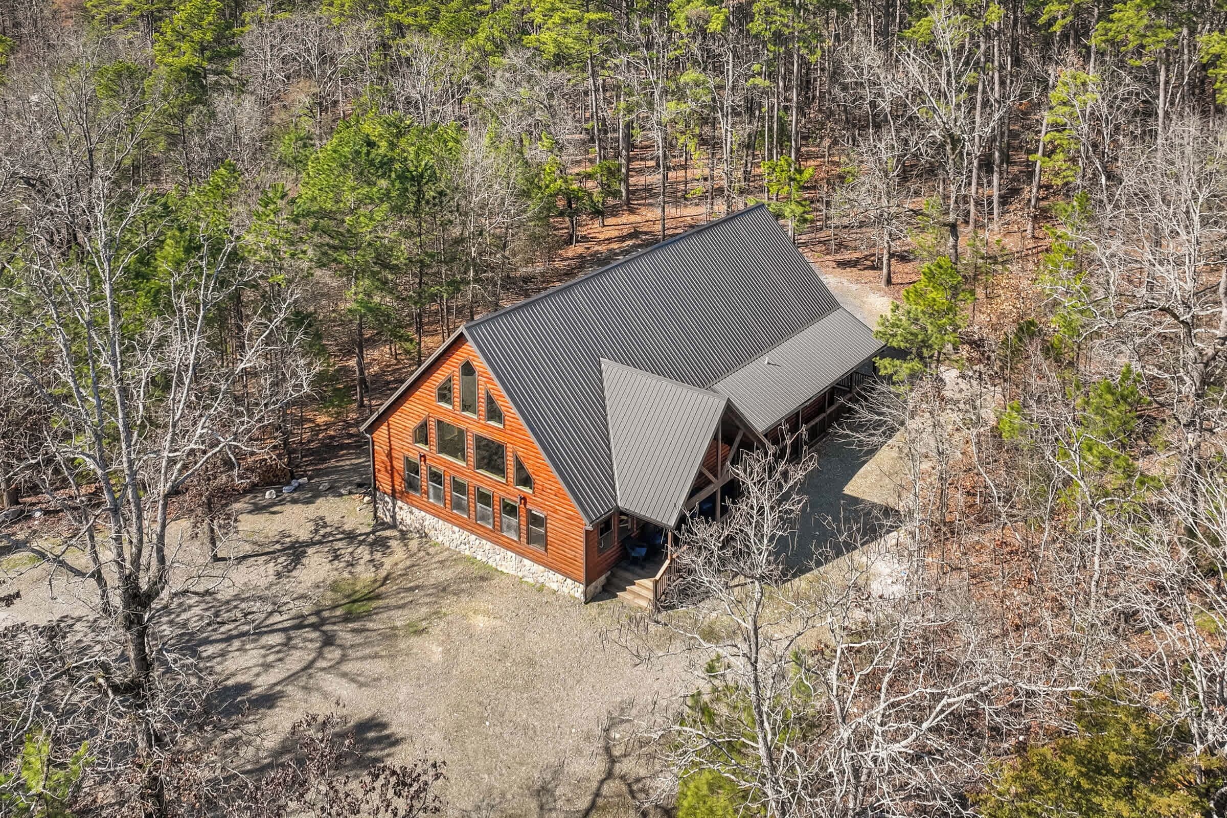 A cabin with a sloped roof, surrounded by trees.
