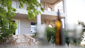 Un edifici de diversos pisos amb escales de pedra que condueixen a un balcó.