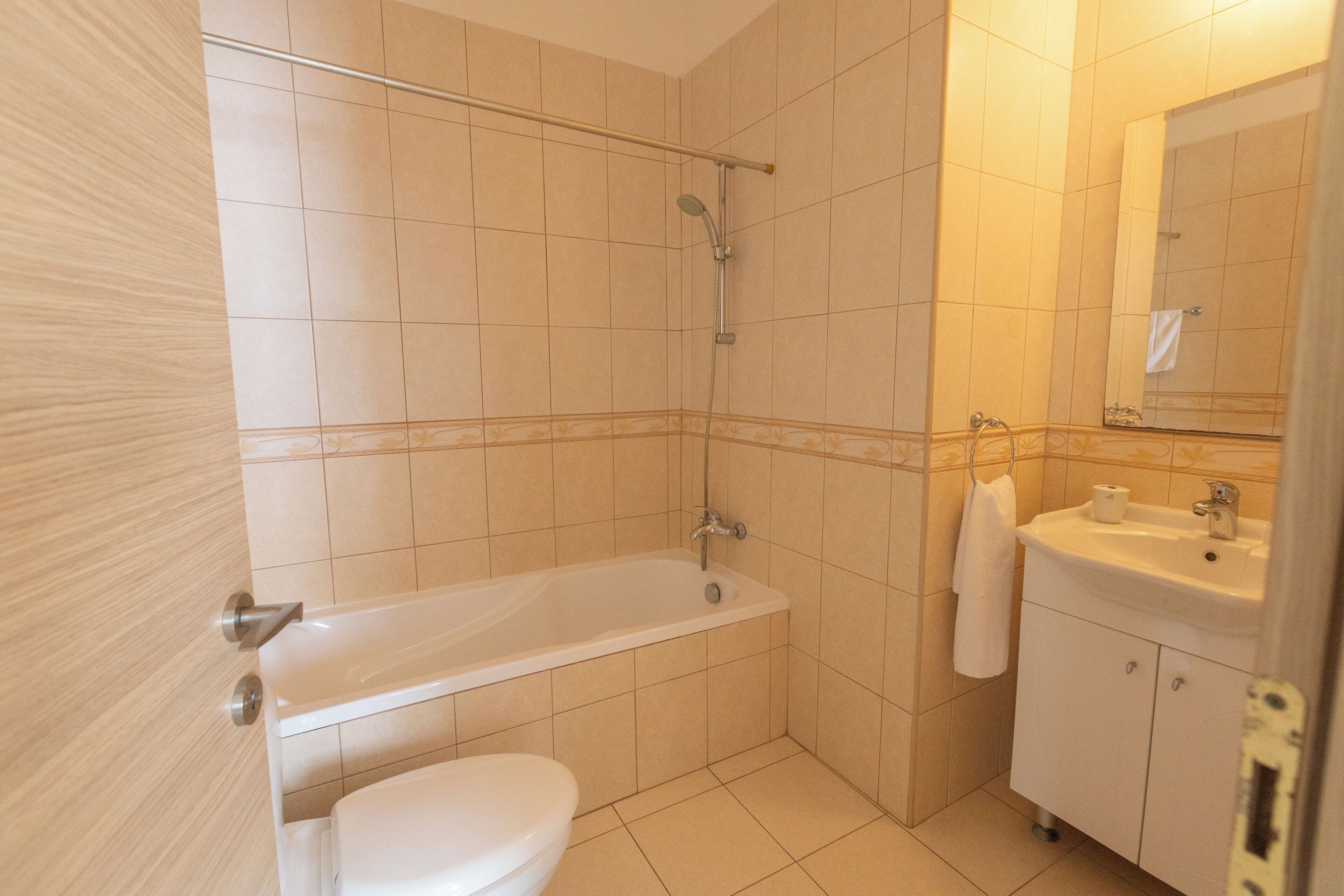 Kylpyhuone, jossa on kylpyamme, wc, pesuallas ja peili.