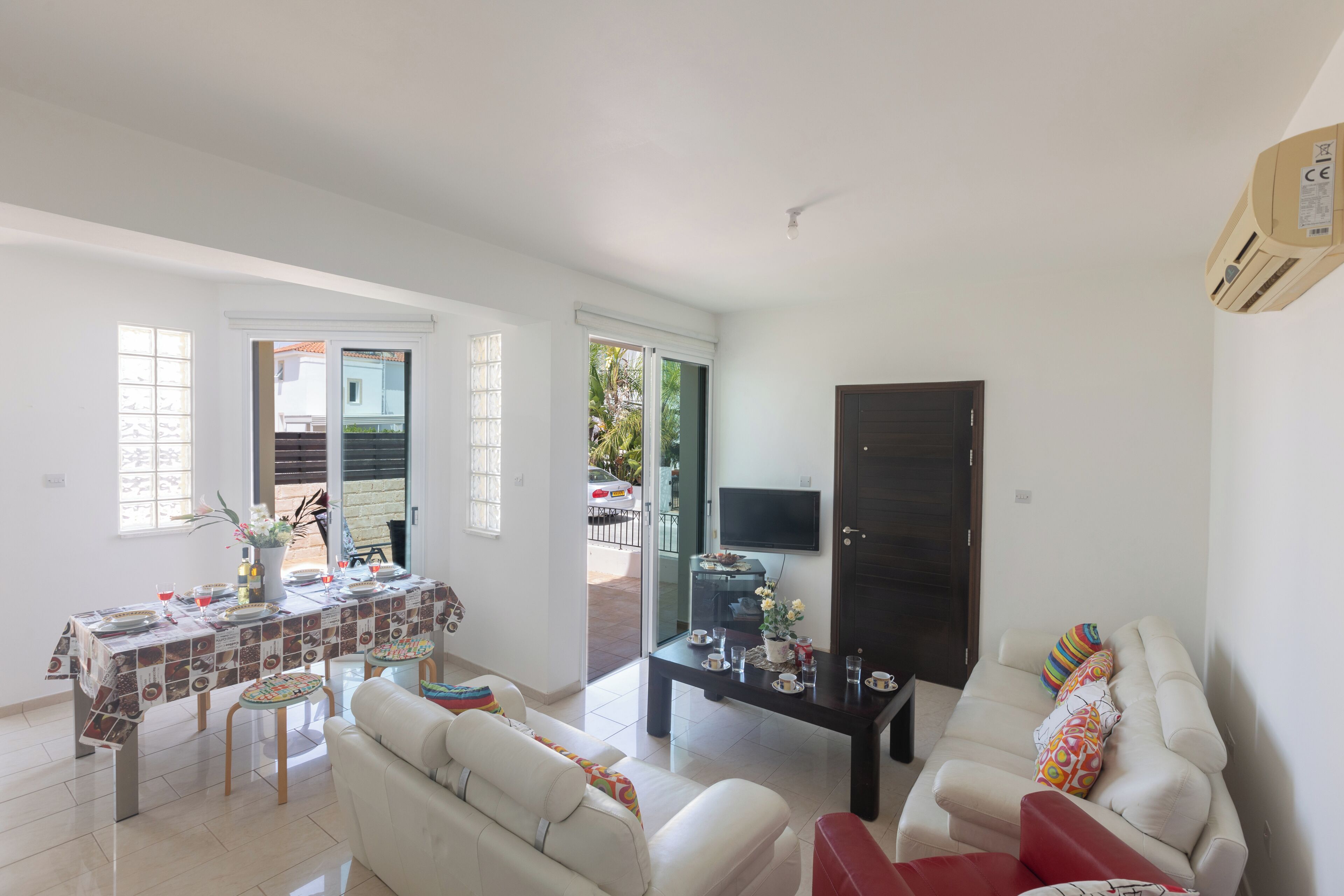 A living room with a sofa, a dining table, and a TV.