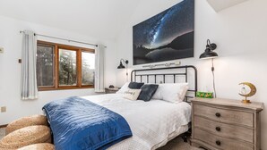 A bedroom with a bed, bedside tables, a nightstand, a dresser, a window with curtains, and a wall-mounted starry night sky artwork. - Unwind at Star Gazer`s Getaway (Galena)