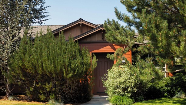 A residential house with a brown exterior, a front porch, and a driveway leading to the entrance. - The Old Mill Retreat Sleeps 6! (Bend)