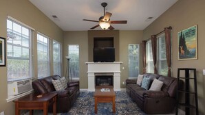 A living room with two brown leather sofas, a wooden coffee table, a fireplace, and a ceiling fan. - The Old Mill Retreat Sleeps 6! (Bend)