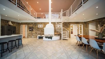 Stunning open-plan living space with a spiral staircase, balcony, and cozy dining area.