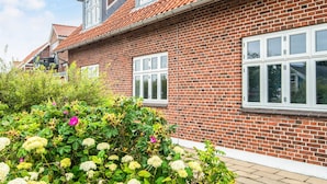 A brick house with a red-tiled roof and white-framed windows. - 2 Person Holiday Home in Ringkobing (Ringkobing)