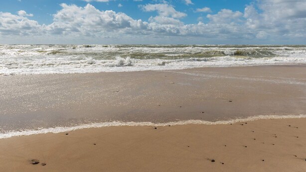 A beach with waves, a clear sky, and scattered clouds. - 2 Person Holiday Home in Ringkobing (Ringkobing)