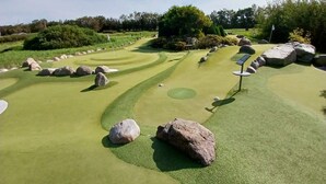 A golf course with multiple holes, bunkers, and a flagstick. - 2 Person Holiday Home in Ringkobing (Ringkobing)