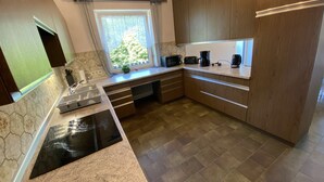 Una cocina moderna con estufa integrada, un fregadero y armarios de madera.