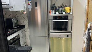 A compact kitchen with a stainless steel refrigerator, a Bosch oven, and a dishwasher. - 154 av al manbat martil  (Martil)