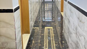 A hallway with marble flooring, wooden doors, and a modern light fixture. - 154 av al manbat martil  (Martil)