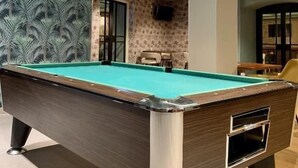 A pool table in a room with patterned wallpaper and a modern ceiling design. - Hostel The Globe (Amsterdam)
