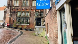 A historic building with a prominent clock tower and a sign for Hotel Globe. - Hostel The Globe (Amsterdam)