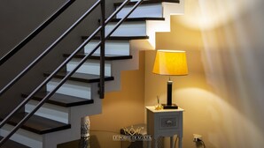 A staircase with a modern design, a small table with a lamp, and a decorative item on the floor. - Loft apartment holiday home catania 4km exclusive center Free parking (Sicilia)