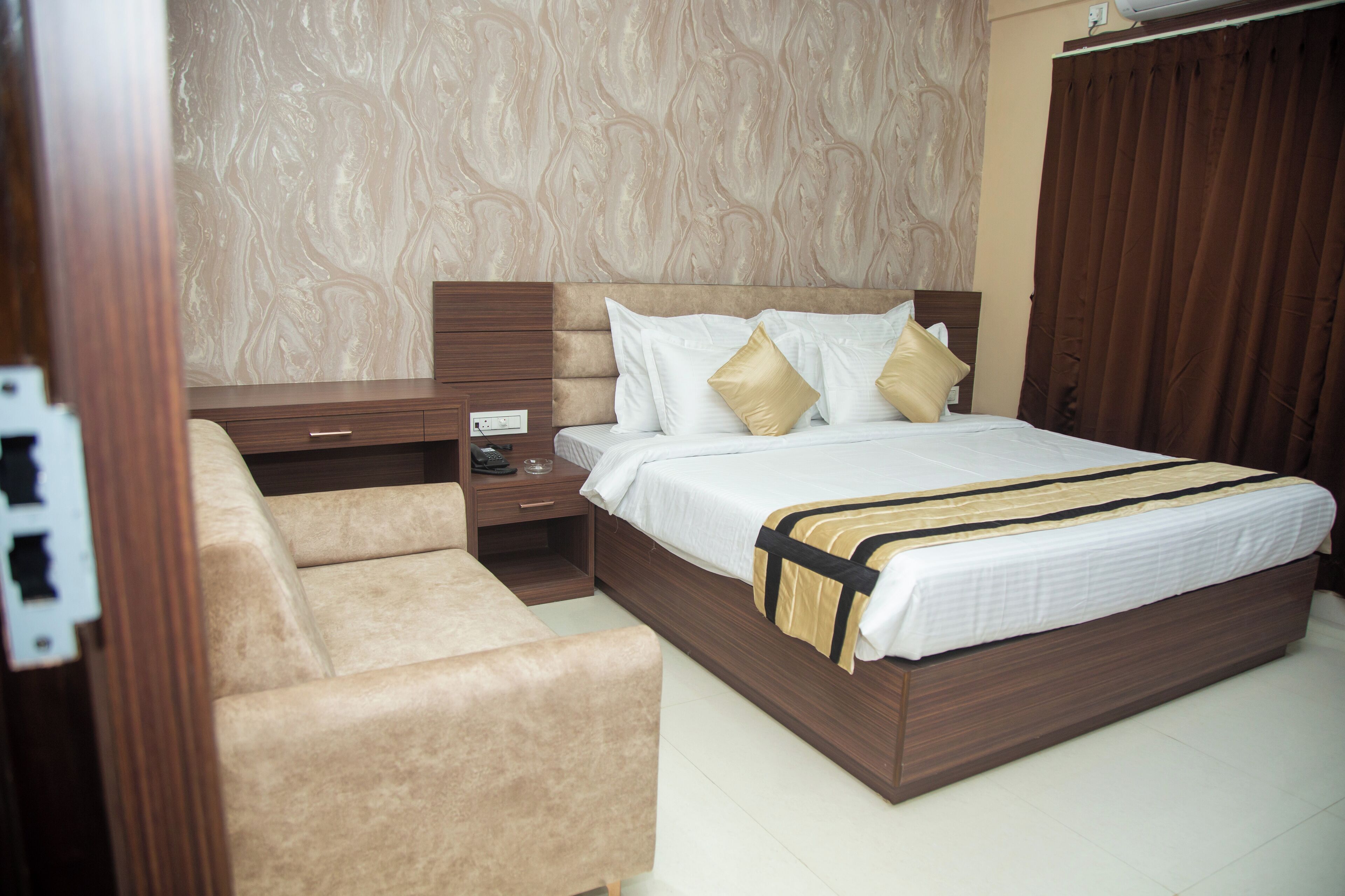 A bedroom with a bed, a nightstand, a dresser, and a chair.