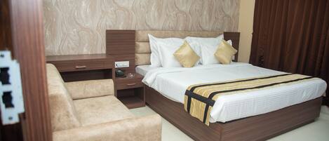 A bedroom with a bed, a nightstand, a dresser, and a chair.
