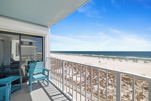 A balcony with a view of the beach and ocean.