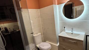 Een douche, handdoeken, toiletpapier