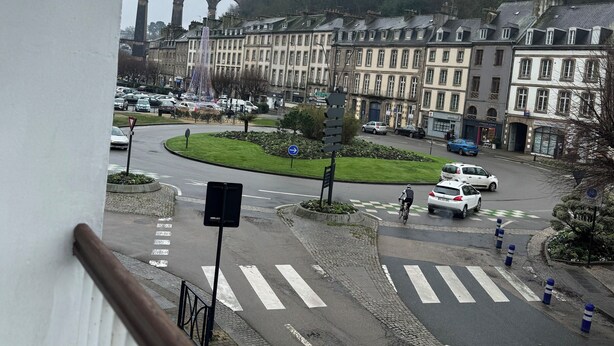 Vista de calle con un puente, edificios y un paso de cebra.