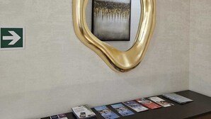 A reception desk with a map and brochures, a directional sign, and a framed artwork on the wall. - Suite with jacuzzi near Vatican (Room 1) (Roma)