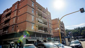 A multi-story brick building with balconies, a café, and a pharmacy. - Suite with jacuzzi near Vatican (Room 1) (Roma)