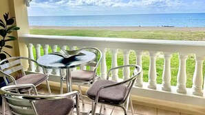 Un balcon avec vue sur la plage et l’océan.