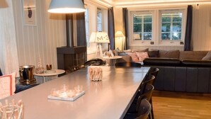 A modern kitchen with a long island, a built-in stove, and a seating area with a sofa and chairs. - 5 Star Holiday Home in Engelsviken (Fredrikstad)