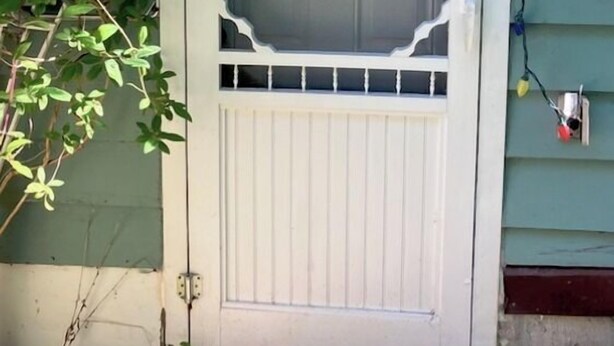 A white front door with a decorative window grille and a small overhang above it. - SPACIOUS ECO-FRIENDLY SUITE with KITCHEN ON PARK (Halifax)