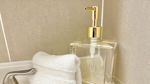 A bathroom with a clear glass bottle of hand soap and a white towel on a sink. - Large and Rare 4-bedroom apartment in amazing New York with WiFi, AC (New York)
