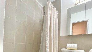 A modern bathroom with a bathtub, toilet, and a shower curtain. - Large and Rare 4-bedroom apartment in amazing New York with WiFi, AC (New York)