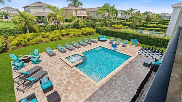 A pool area with lounge chairs, a hot tub, and a chess table. - Themed Bedrooms and Games Room/Private Pool and Spa/10 Mins Disney/Outdoor Chess (Kissimmee)