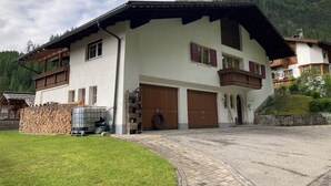A two-story chalet with a sloped roof, wooden balconies, and large garage doors.