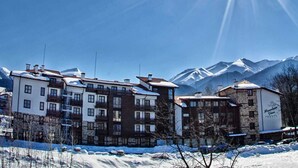 Un hôtel composé de plusieurs bâtiments, entouré d’un paysage enneigé et adossé à une montagne.
