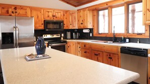 A kitchen with wooden cabinets, a stainless steel refrigerator, a microwave, an oven, a sink, and a dishwasher. - Cozy 3-bedroom cabin in charming Crosslake with WiFi and AC (Crosslake)