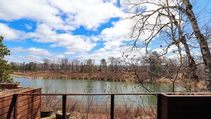 A wooden deck overlooking a lake with trees and a clear sky. - Cozy 3-bedroom cabin in charming Crosslake with WiFi and AC (Crosslake)