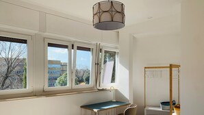 A room with a desk, chair, and a hanging clothes rack. - Cozy apartment for two to four people near the Auditorium in Rome (Roma)