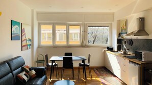 A modern kitchen with a dining area, a sofa, and a window with a view. - Cozy apartment for two to four people near the Auditorium in Rome (Roma)