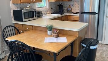 Una cocina moderna con armarios de madera, electrodomésticos de acero inoxidable y una isla central con sillas.