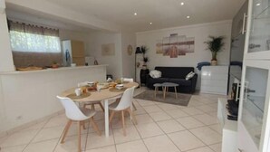 Un espace de vie compact comprenant un coin repas, une kitchenette et un coin salon.
