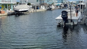 A marina with boats docked, a covered boat, and buildings with American flags. - 3-bedroom mobile home in soothing Key Largo with WiFi, AC (Key Largo)