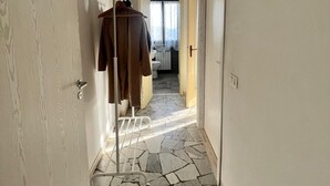 A narrow hallway with a stone floor leading to a bathroom. - Mantua Palace (Cremona)