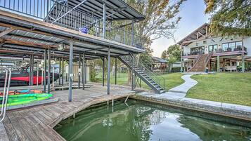 Una terraza de varios niveles con piscina, asientos al aire libre y una escalera que lleva a un segundo piso.