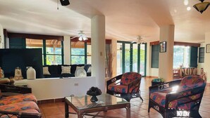 A spacious living area with a sofa set, a coffee table, and a television. - Casona Mirimou-Country and Beach House! (Luquillo)