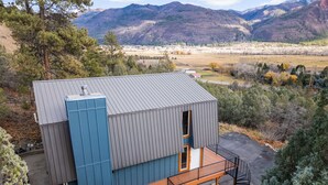 A modern building with a metal roof, a wooden deck, and a hot tub in front. - Newly Remodeled Mountain Cabin w/ Epic Views, A/C, Optional Hot tub, 2 Kitchens (Durango)